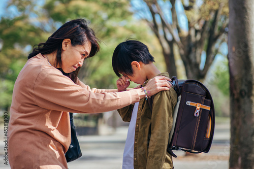 泣く小学生と心配する女性 