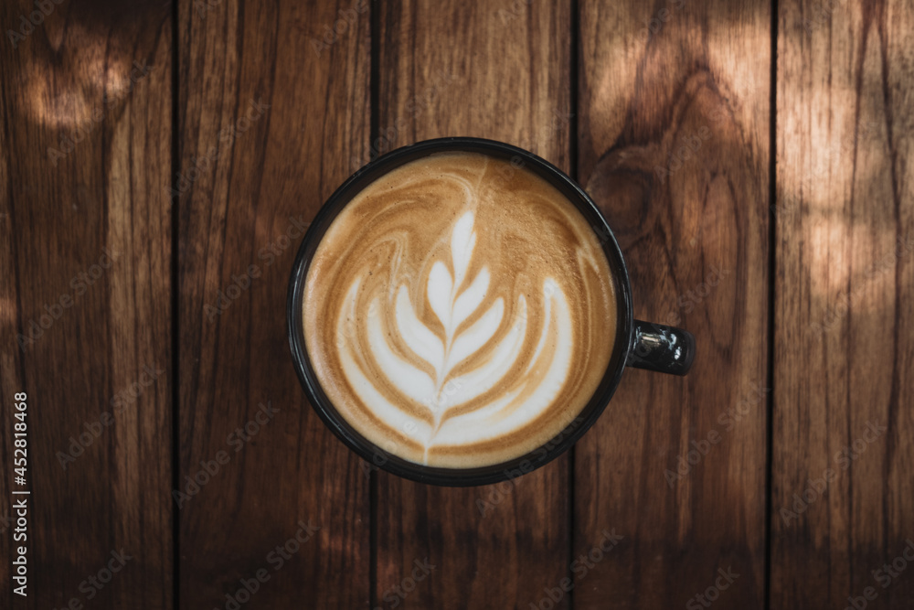 Latte art coffee on wooden table in coffee shop Latte art coffee on wooden table in coffee shop