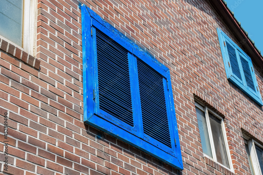 Vintage blue window on brick wall of the building