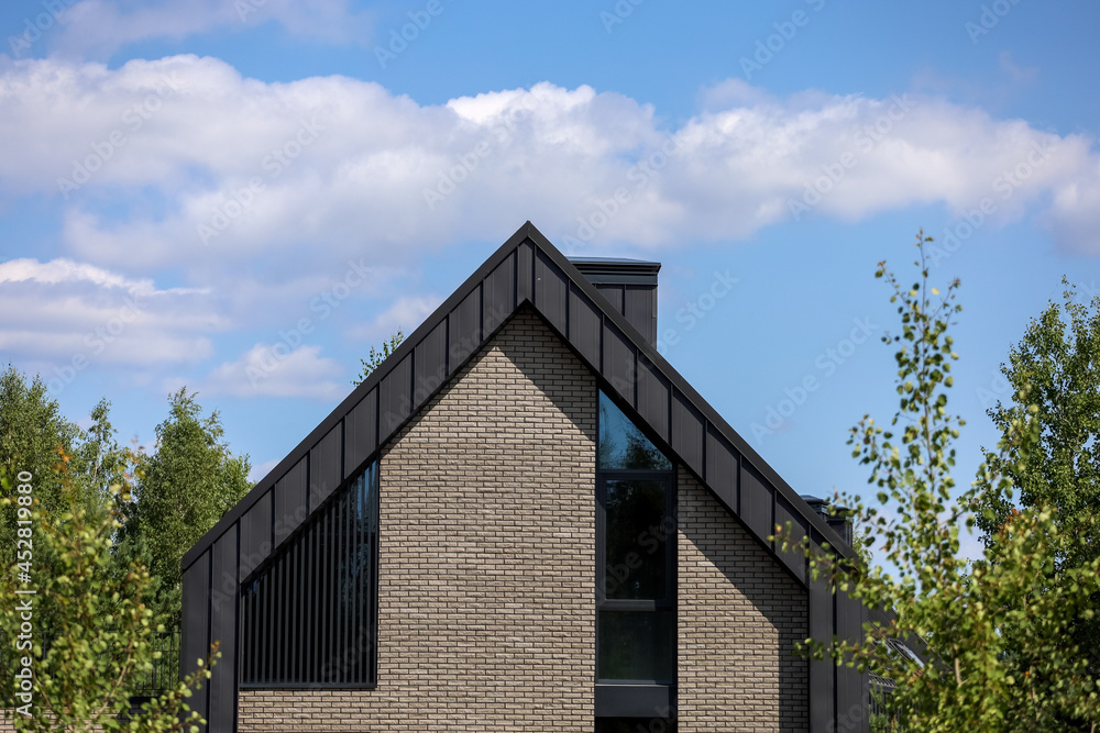 A modern family home with a trendy design. Gray roof, sand walls. A modern family home with a trendy design. Gray roof, sand walls.