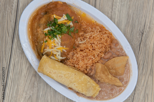 Foto Overhead view of hearty plate of chili relleno smothered in wet sauce served wit
