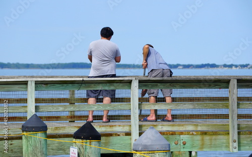 Two guys crabbing on Romancoke fishing pier in the hot summer day near Kent Island, Maryland, U.S.A photo