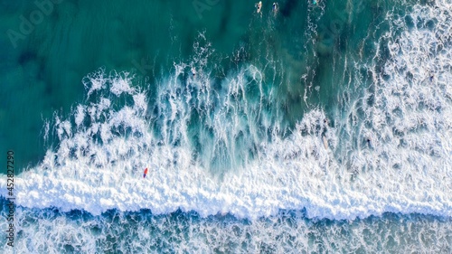 Aerial view over surfers in the ocean waves