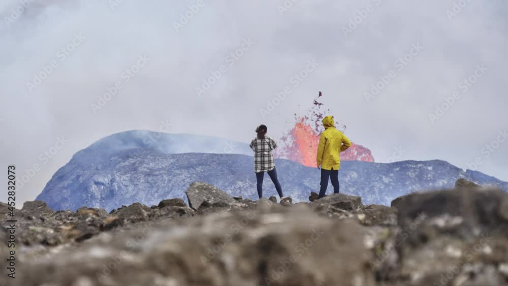 Couple of Travelers Appreciating the Landscape of an Erupting Volcano Couple of Travelers Appreciating the Landscape of an Erupting Volcano