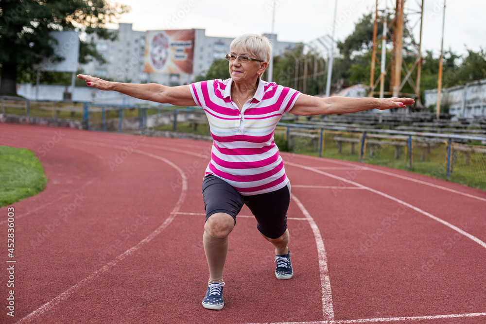 older woman doing gymnastics and running in the stadium, person running older woman doing gymnastics and running in the stadium, person running