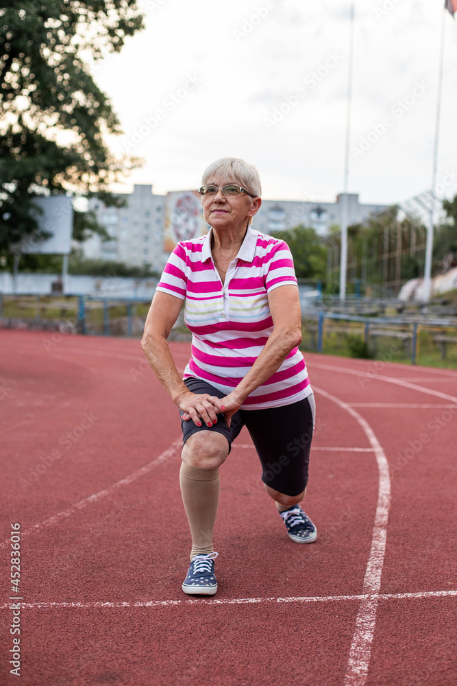 older woman doing gymnastics and running in the stadium, person running