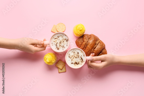 Two hands holding coffee cu...