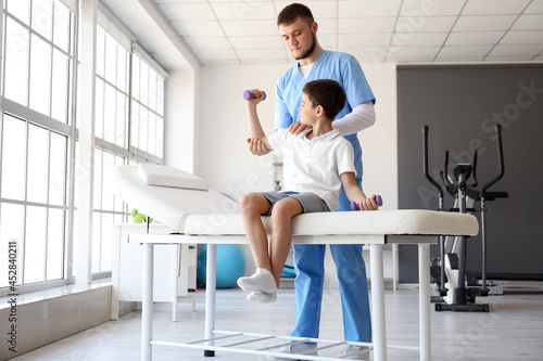 Physiotherapist working with boy in rehabilitation center