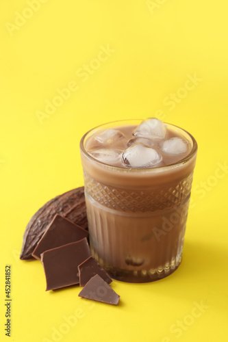 Glass of tasty chocolate milk on color background