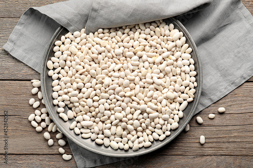 Φωτογραφία Plate with raw beans on wooden background