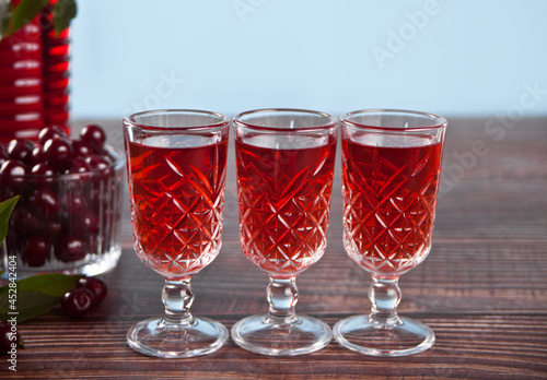 Photos glasses of cherry brandy liqueur with ripe berries
