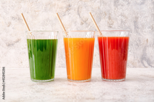 Glasses with healthy juice on light background