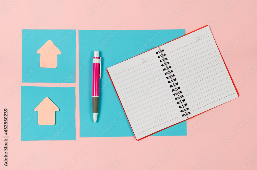 Sheets of a paper, open notebook, arrow bookmarks, pen on pink b Sheets of a paper, open notebook, arrow bookmarks, pen on pink b