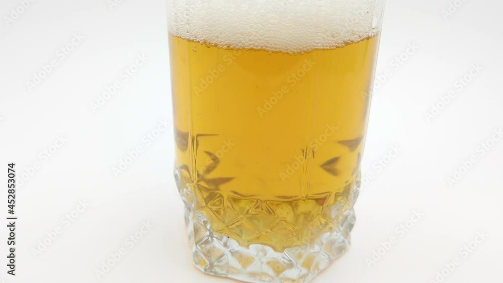 Blond and bubbled beer served on white screen Blond and bubbled beer served on white screen