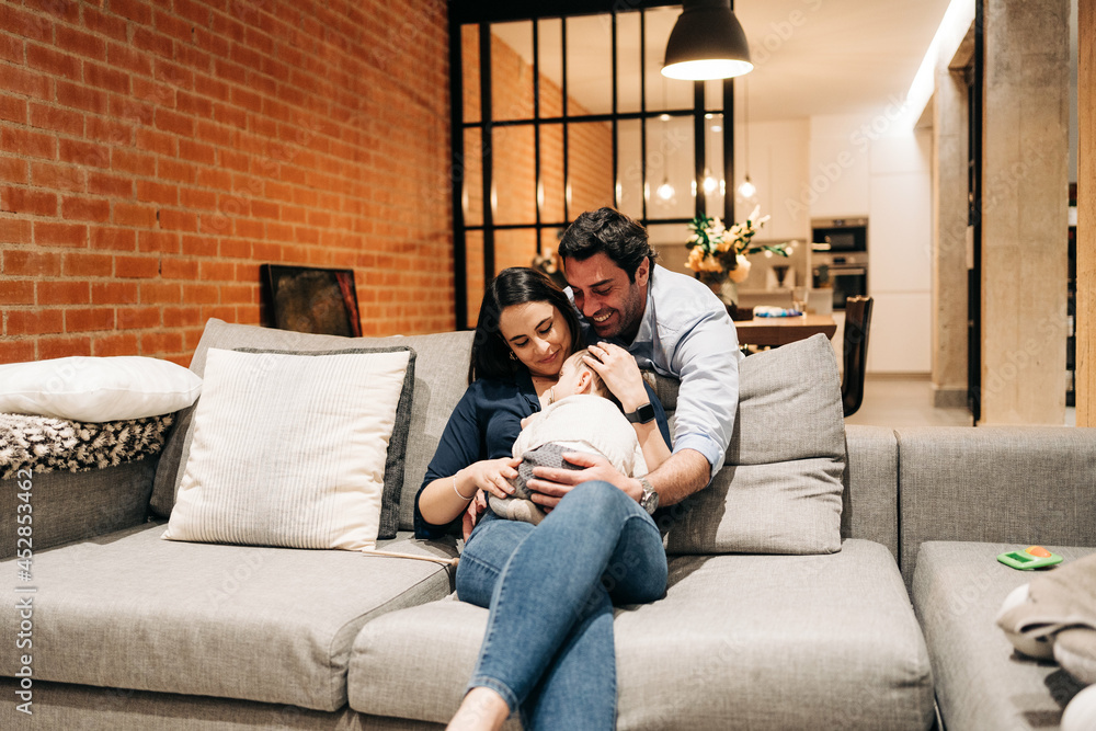 happy young family at home cuddling while baby is taking a nap happy young family at home cuddling while baby is taking a nap