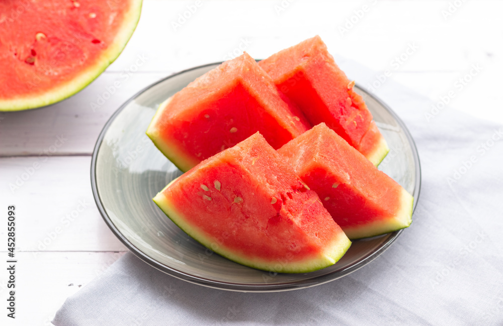 Watermelon slices on a plate, close up. Watermelon without black seeds. Watermelon slices on a plate, close up. Watermelon without black seeds.