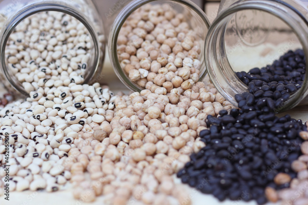 Obraz premium Jars of Black-eyed Peas, Chick Peas, Black Beans and Pinto Beans Spilled in Kitchen
