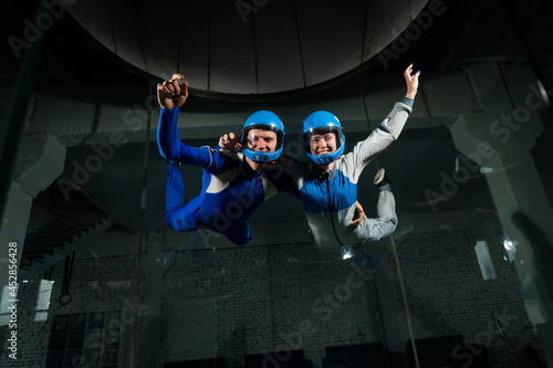 A man and a woman enjoy flying together in a wind tunnel. Free fall simulator photo