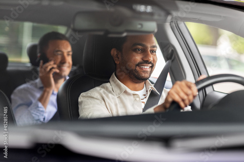transportation, vehicle and people concept - happy smiling indian male driver driving car with passenger © Syda Productions