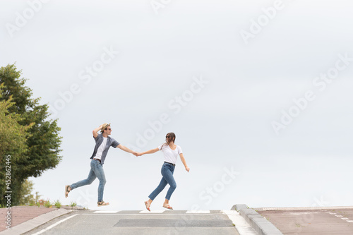 Happy couple crossing the road running. Happiness concept with minimalist composition and copy space.
