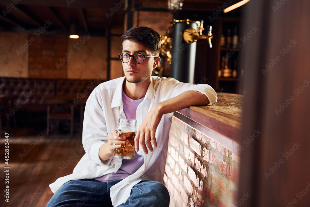 On the chair. Man in casual clothes sitting in the pub On the chair. Man in casual clothes sitting in the pub