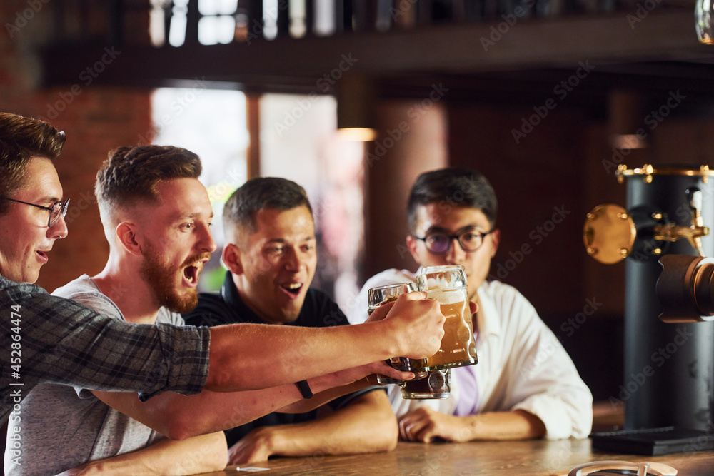 People in casual clothes sitting in the pub and drinking beer