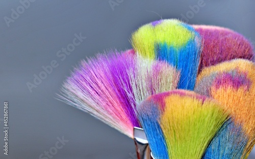 Bright rainbow makeup brush close-up gray background