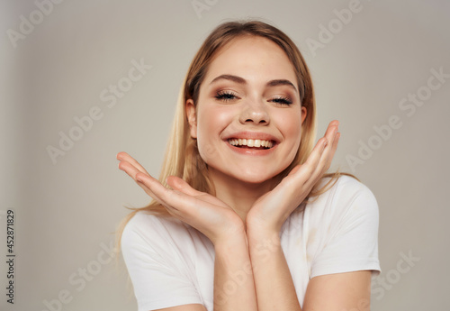 beautiful blonde in a white positive posing joy smile light background