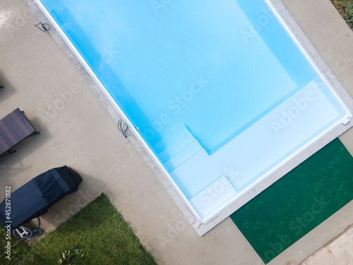 aerial drone flight of pool build construction site with pool filled with water in a garden © epiximages