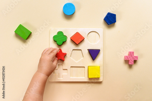 The child collects a multicolored sorter. Educational logic toy for kid's