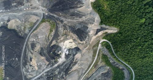 Aerial moving footage of a coal mine surrounded by woods photo
