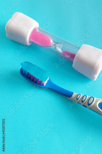 Blue background with a toothbrush and hourglass, kids brushing time