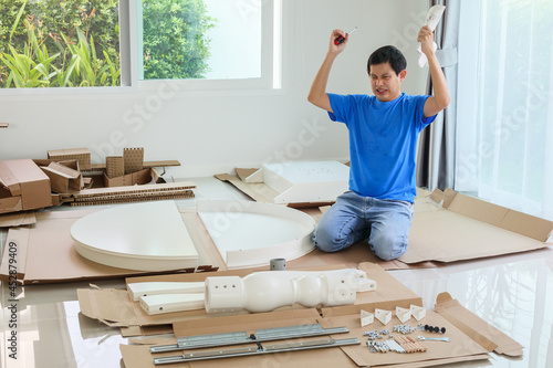 Foto Man assembling white round table furniture at home