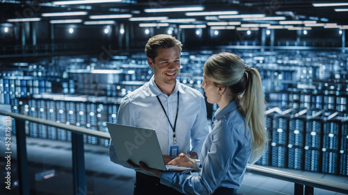 Tableau sur toile Data Center Female e-Business Enrepreneur and Male IT Specialist talk, Use Laptop