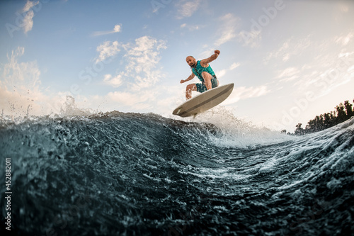 Energy man jumping on wakeboard down the river waves. Wakesurf training © fesenko