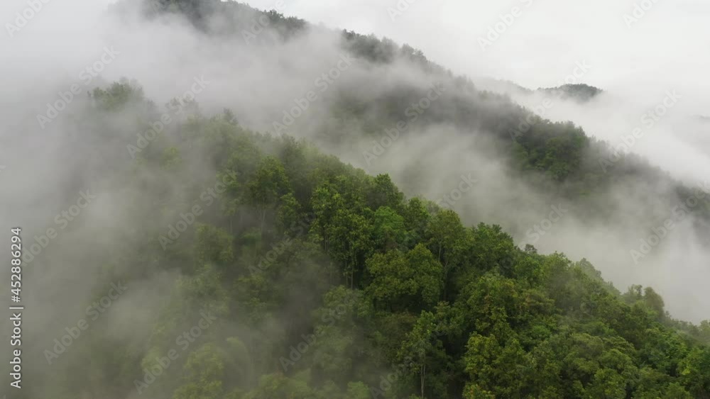 Aerial view flying above lush green tropical rain forest mountain with rain cloud cover during the rainy season on the Doi Phuka Mountain reserve national park. In, the northern Thailand Aerial view flying above lush green tropical rain forest mountain with rain cloud cover during the rainy season on the Doi Phuka Mountain reserve national park. In, the northern Thailand