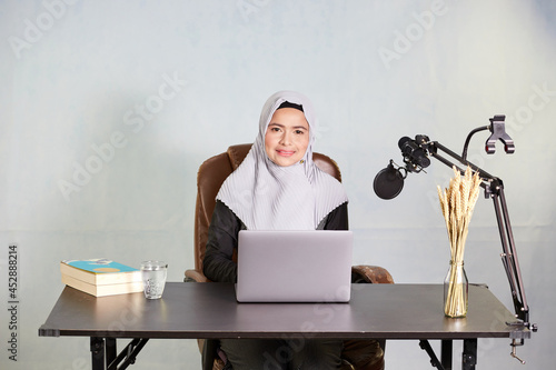 muslim business woman smiling working on laptop computer and look at camera 