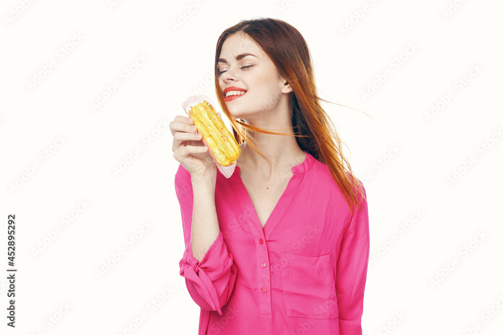 woman eating eclair Glamor snack close-up light background woman eating eclair Glamor snack close-up light background
