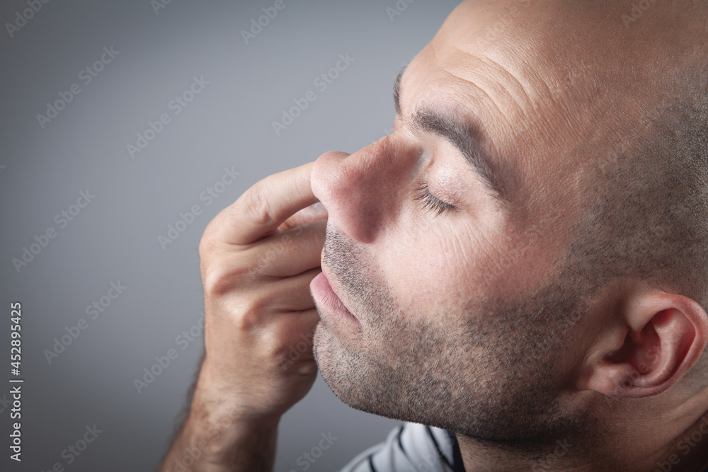Fototapeta premium Young man with finger in his nose.