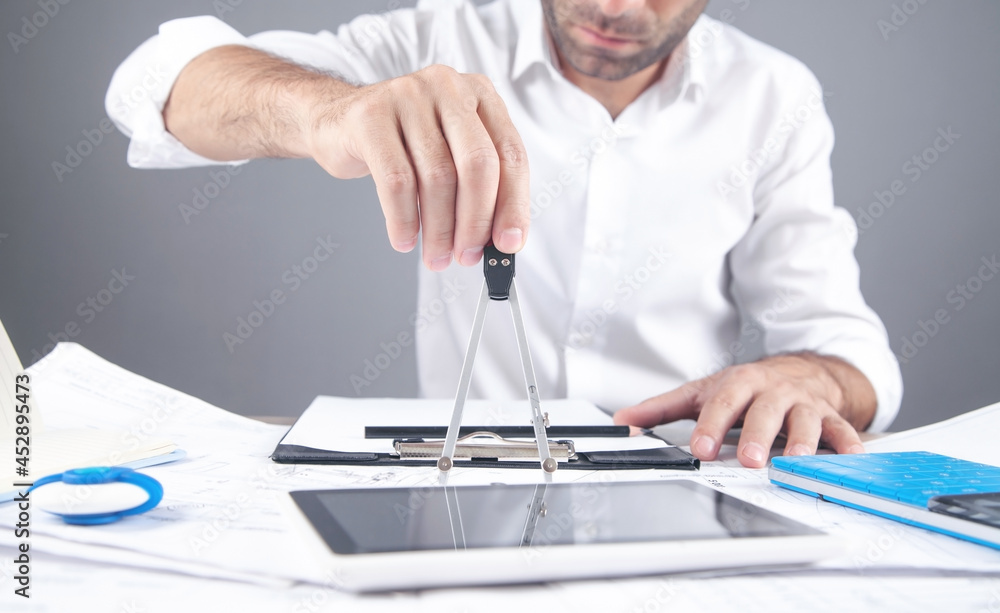 Architect using compass tool. Drawing construction plan Architect using compass tool. Drawing construction plan