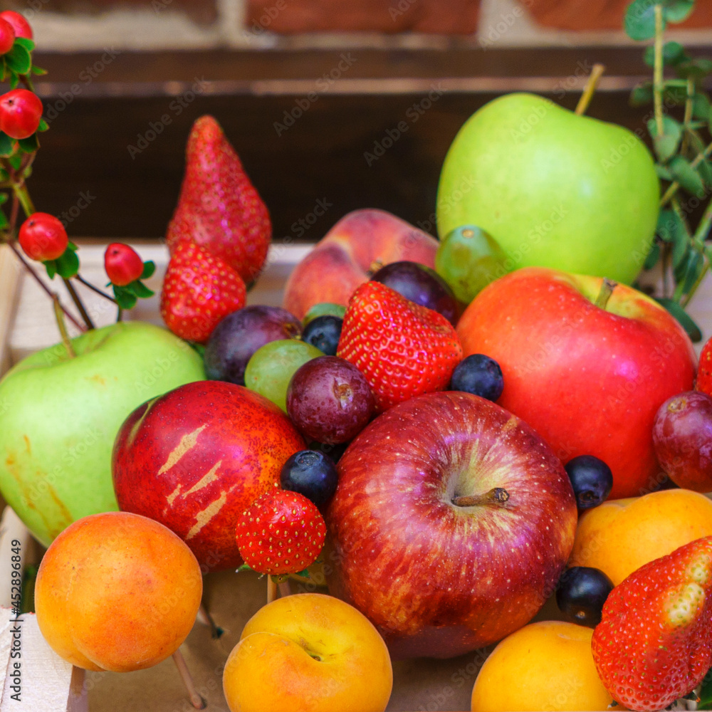 Summer fruit, berry assortment. Big apple, plum, apricot, grape and strawberry. Colorful berries in wooden crate on the table. Summer fruit, berry assortment. Big apple, plum, apricot, grape and strawberry. Colorful berries in wooden crate on the table.