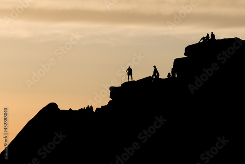 Striking sunset scene of stanage edge rock formations. People on top