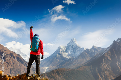 Hiker cheering elated and blissful with arms raised in the sky after hiking. Everest base camp trek photo