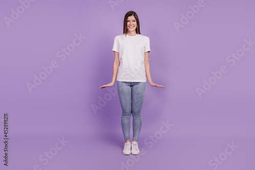 Photo of cheerful charming girl standing isolated over violet background