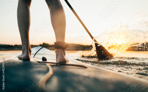 Photos Close up of man paddleboarding at sunset