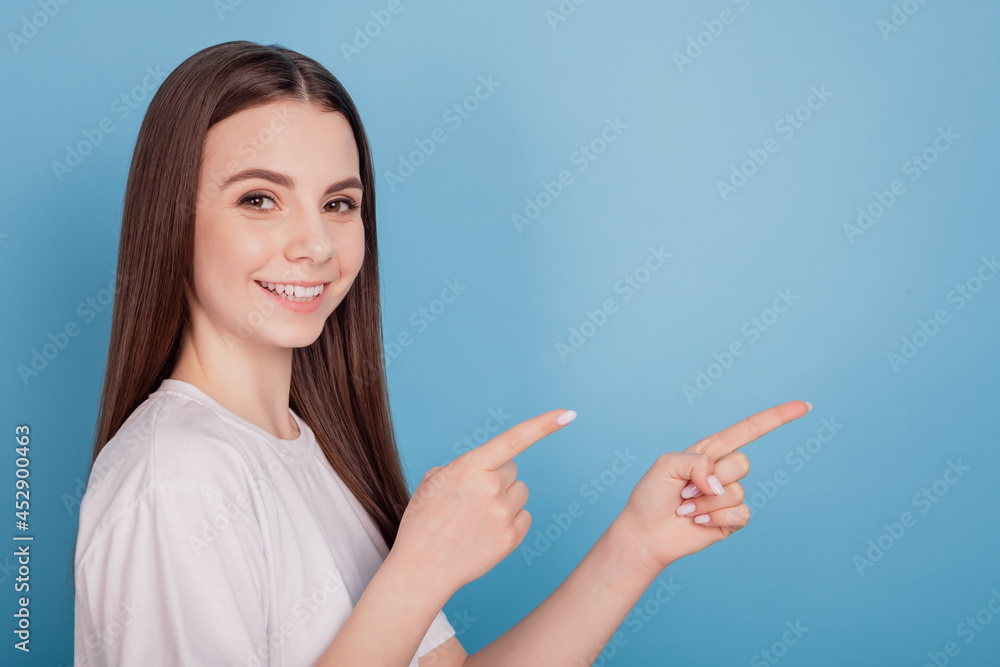 Portrait of reliable promoter lady look camera direct fingers empty space on blue background Portrait of reliable promoter lady look camera direct fingers empty space on blue background