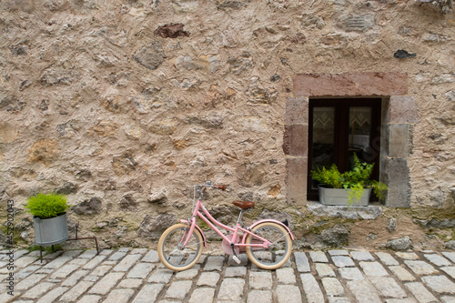 girl's pink bicycle on stone facade