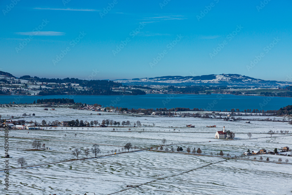 ドイツ　ノイシュヴァンシュタイン城から見える雪景色の平原と湖