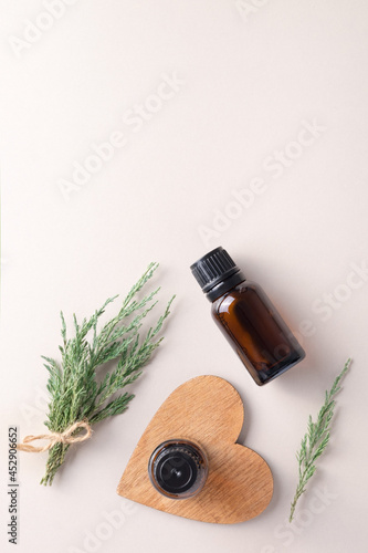 Juniper essential oil. A branch of juniper, oil in a small glass bottle. Copy Space