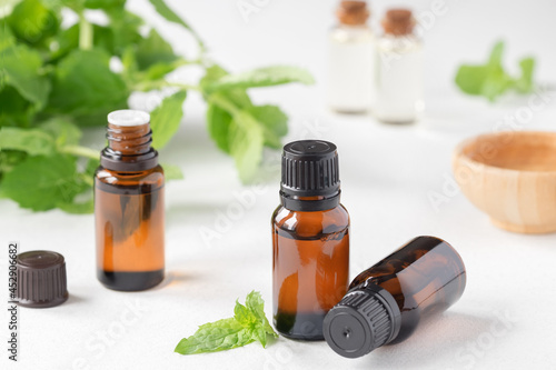 Mint essential oil. Mint leaves  oil in small glass bottles.